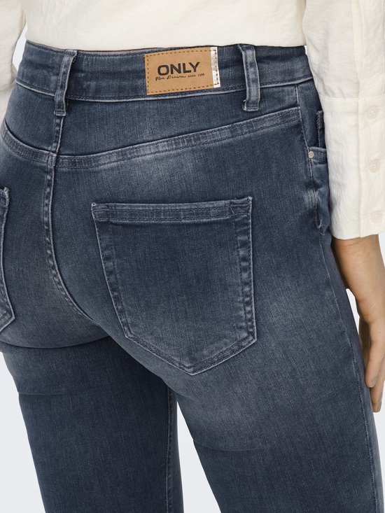 Detail van de achterkant van een blauwe jeans met een bruin leren label met het ONLY-logo.
