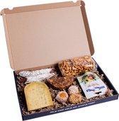Gouden kaas, worstjes, koekjes, pretzels en tapenade in een doos.