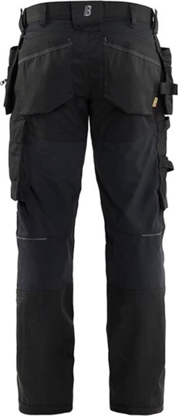 Arrière d'un pantalon de travail noir avec de nombreuses poches et genoux renforcés.