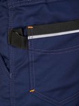 Pantalon de travail bleu marine avec une bande noire sur la poche et un passepoil réfléchissant.