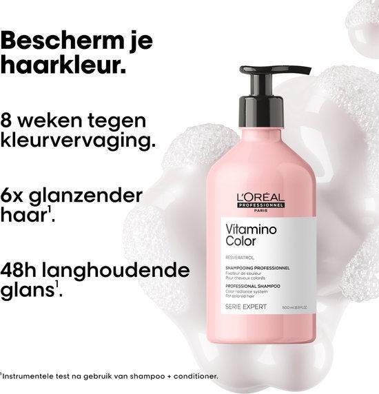 Roze fles L'Oréal Professionnel Vitamino Color shampoo met pompje, omringd door witte schuimachtige bubbels.