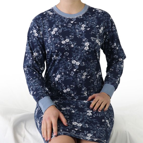 Model zittend in een donkerblauw nachthemd met lange mouwen en een bloemenprint.
