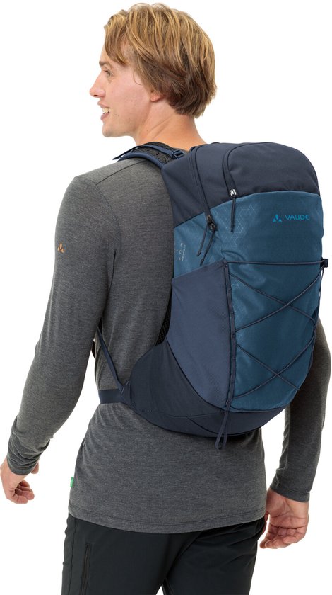 Man met een donkerblauwe Vaude rugzak op de rug.