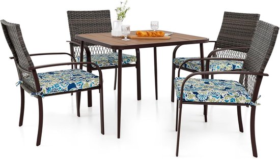 Bruine rotanstoelen met blauwgroene bloemenkussens, rond een bruine tafel.