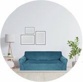 Een groenblauwe stretch bankhoes over een 4-zits bank in een woonkamer.