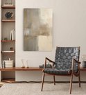Abstract doek met beige en grijstinten, in een zithoek met stoel.