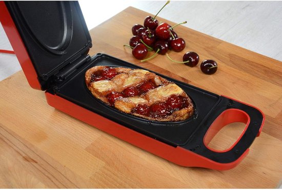 Rode grill met open deksel, met een appelkruimeltaart en kersen.