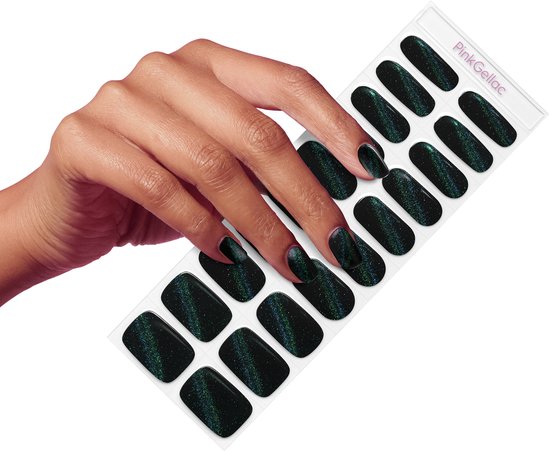 Hand met donkerzwarte nagelstickers met glinsterend cat-eye effect, naast een vel met stickers.