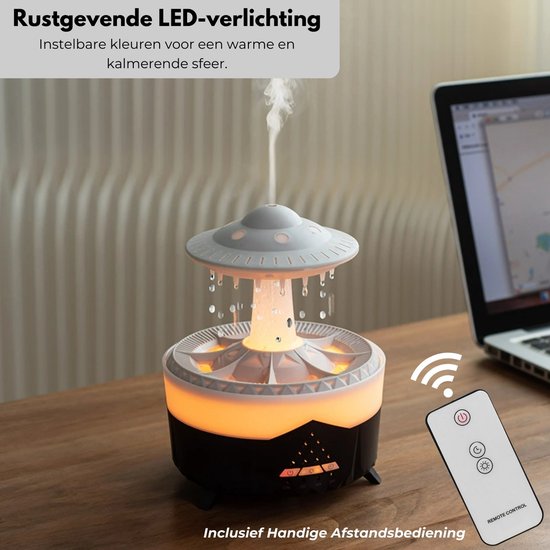 Grijze UFO-aroma diffuser met oranje gloed en druppelende waterimitatie, naast een laptop. Met afstandsbediening.