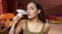 Vrouw met donker haar gebruikt het witte Philips Lumea IPL ontharingsapparaat op haar gezicht.