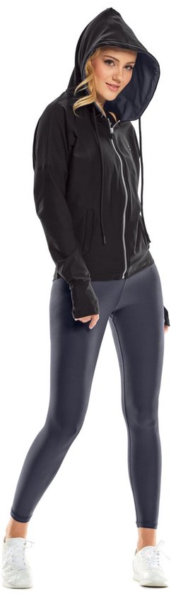 Vrouw met blond haar in zwarte open rits hoodie en grijze legging, staand.