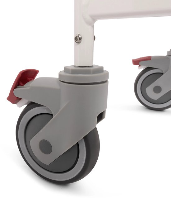 Dichtbij detailopname van de grijze zwenkwielen met rode remhendels van een witte stoel.