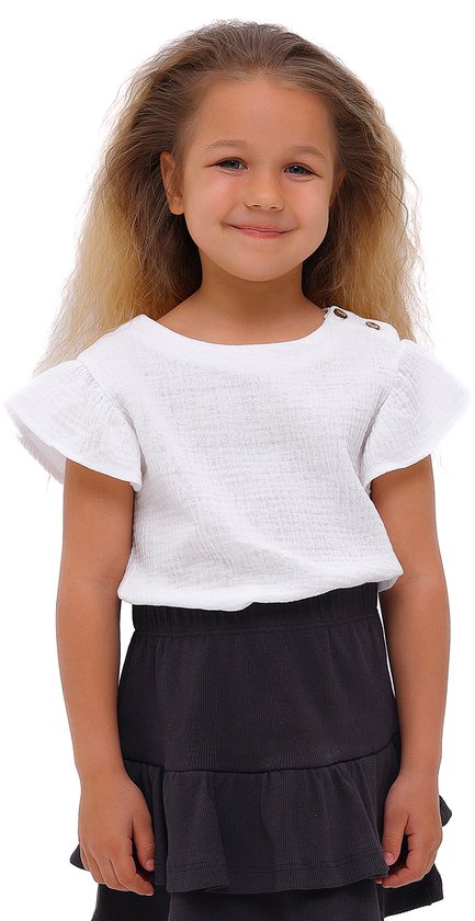 Meisje met lang blond haar, draagt een wit T-shirt met pofmouwen en gouden knopen, en een donkere A-lijn rok met ruches.