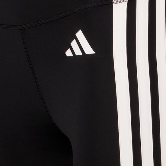Close-up van het Adidas logo en de witte strepen op een zwarte sportlegging.