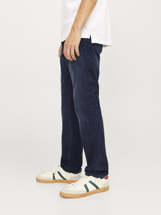 Man met donkere jeans en sneakers.