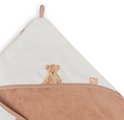Gros plan sur la pointe d'une cape de bain blanc cassé avec imprimé ours en peluche et bordure beige. Le logo Jollein est visible.