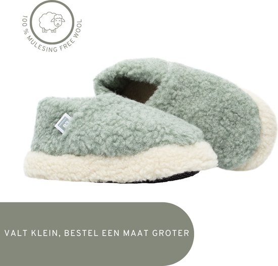Schuin aanzicht van twee groene wollen pantoffels met witte randen en het "100% Mulesing Free Wool" logo.