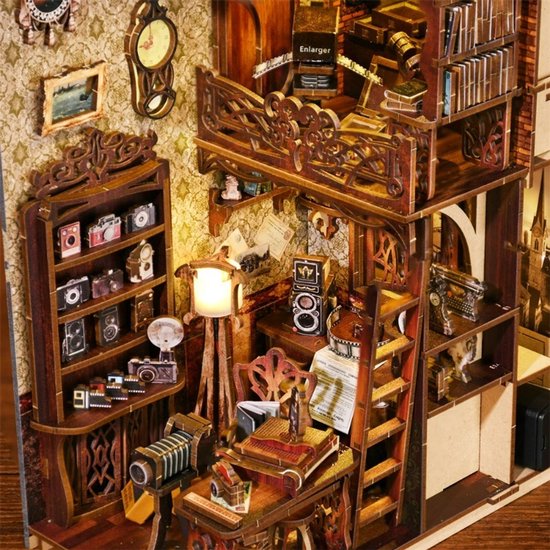Gedetailleerd interieur van een miniatuur filmdarkroom met camera's, boeken en meubels.