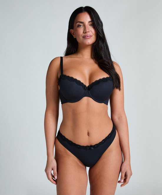 Model in zwarte voorgevormde beugel bh met geribbelde stof, kanten rand en strikje.