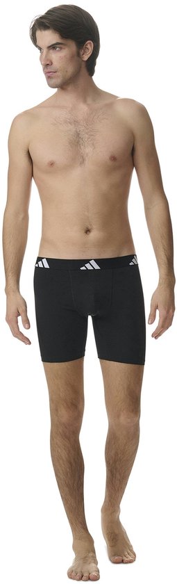 Model in zwart boxerhort met zwarte band met witte Adidas logo's.