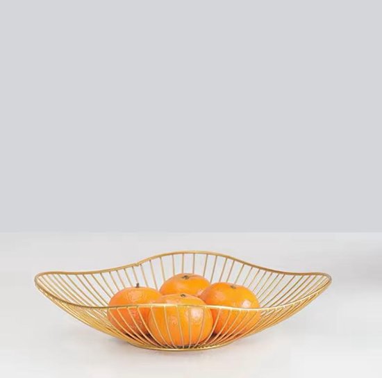 Gouden metalen fruitschaal gevuld met vier sinaasappels.