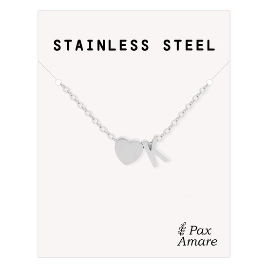 Collier argenté avec un cœur et la lettre K, sur une carte avec 'STAINLESS STEEL' et 'Pax Amare'.