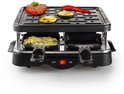 Zwarte gourmetset met op de plaat gegrilde biefstuk, courgette en peper, en kazen in de pannetjes.