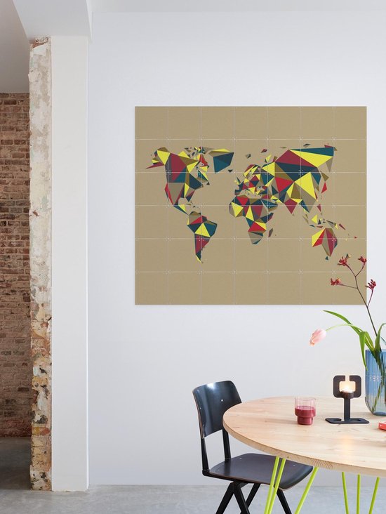 Carte du monde avec des motifs géométriques rouge, jaune et bleu, accrochée au mur au-dessus d'une table à manger.