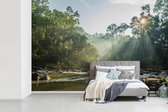 Behang - Fotobehang De zon schijnt op een rivier in een Maleisisch bos - Breedte 420 cm x hoogte 280 cm
