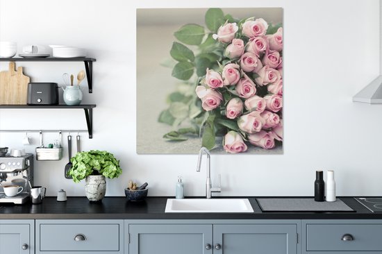 Un grand livre de roses roses repose sur une table Toile 90x90 cm - Tirage photo sur toile (Décoration murale salon / chambre) / Peintures Fleurs sur toile