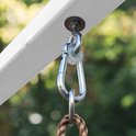 Detail van metalen karabijnhaak die een schommelkoord aan een wit houten balk bevestigt.