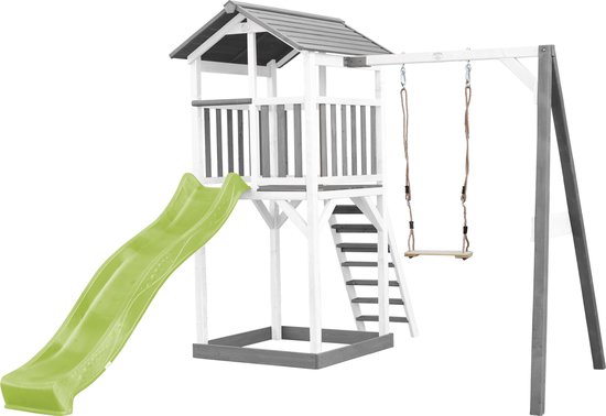 Speeltoren van hout met groene glijbaan en schommel, wit met grijze details.