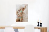 Canvas Schilderij Vrouw die in een gekleurde bikini op bed ligt - 40x60 cm - Wanddecoratie