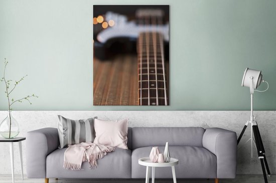 Une guitare basse repose sur le sol Toile 120x160 cm - Tirage photo sur toile (Décoration murale salon / chambre) XXL / Groot format!