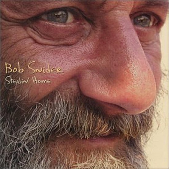 Close-up van een oudere man met blauwe ogen, een ruige grijze baard en een gerimpelde huid. Tekst: "Bob Snider Stealin' Home".