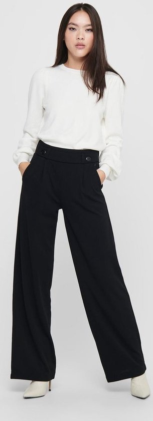 Zwarte wijde broek met hoge taille, gedragen door een model met een witte trui.