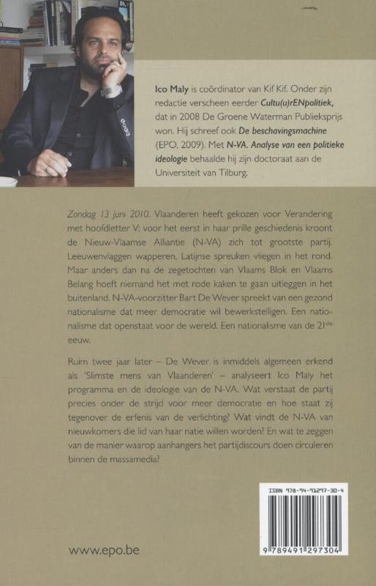 Een man in een zwart pak zit aan een tafel en kijkt naar de camera. De achterkant van het boek heeft tekst.