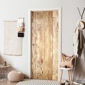 Zelfklevende deurposter met verweerde houten planken print, toegepast op een binnendeur in een hal.