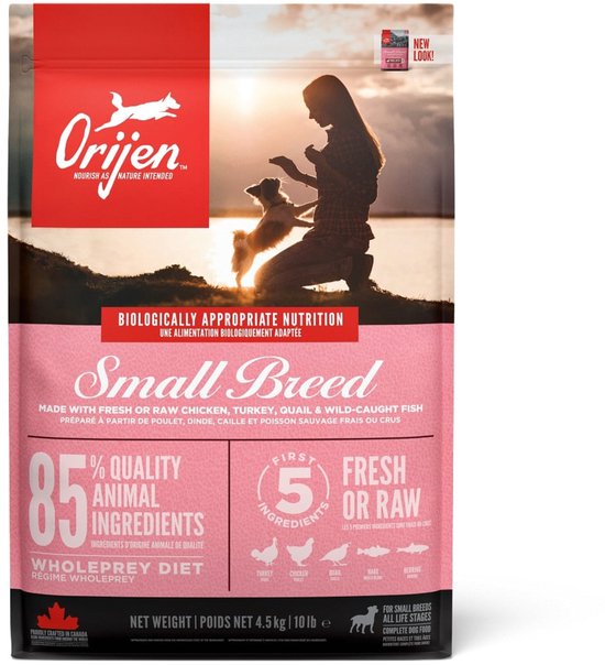 Orijen Small Breed hondenvoerzak, roze met afbeelding van vrouw en hond bij zonsondergang.