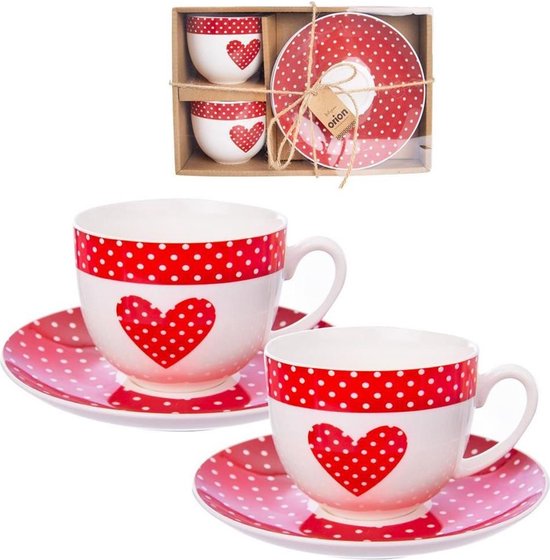Deux tasses à café blanches avec des pois rouges et des cœurs sur des soucoupes roses à pois rouges, en emballage.