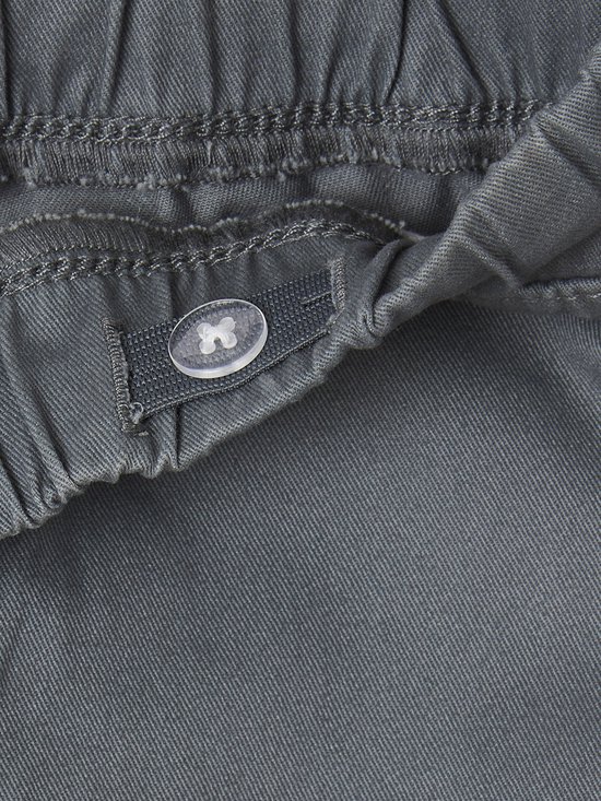 Sluiting van een grijze joggingbroek met knoop aan de binnenkant van de tailleband.