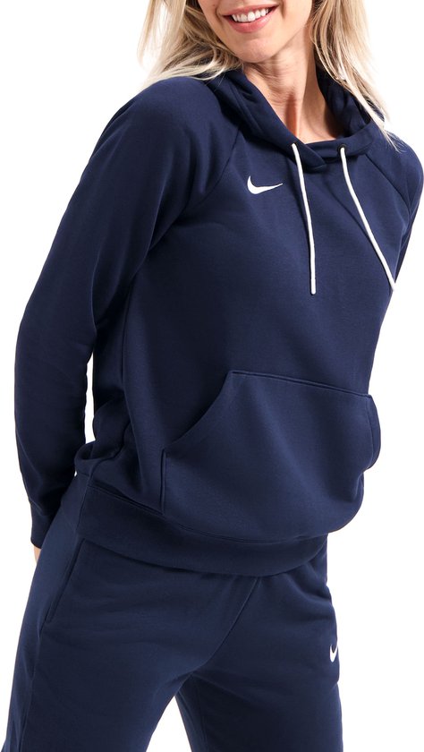 Model met lachend gezicht draagt een donkerblauwe Nike hoodie en joggingbroek.