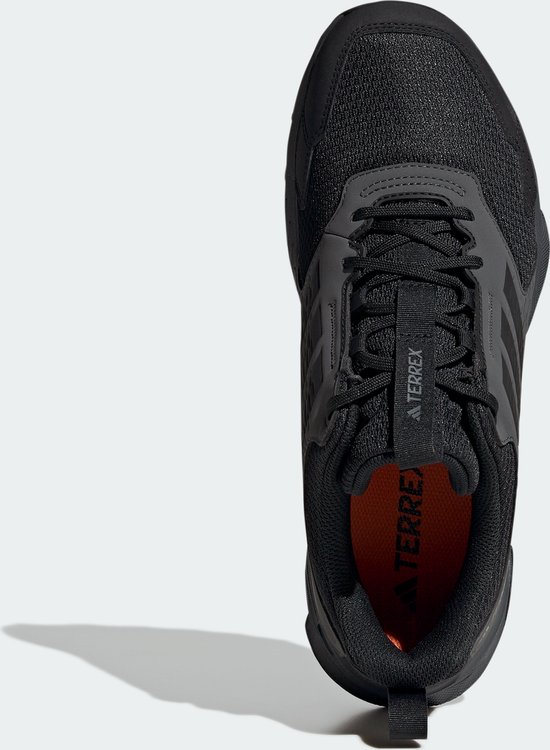 Bovenkant van een zwarte Adidas Terrex trailrunningschoen met oranje voering.