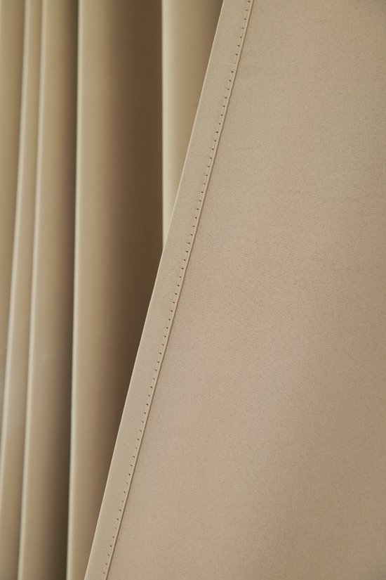 Detail van een licht taupe gordijn met gestikte naden en plooien.