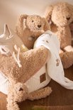 Beige gebreid mandje met teddy konijntjes en babykleding.