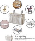 Wit stoffen bedorganizer met meerdere vakjes en haken, staand op een bed. Toont gebruiksmogelijkheden bij een ledikant, ziekenhuisbed, kinderwagen en stoel.