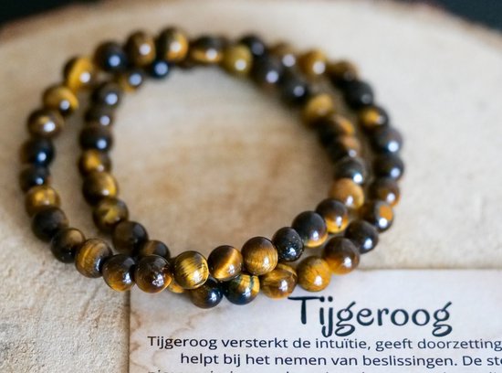 Deux bracelets en perles d'œil-de-tigre aux rayures brunes et dorées, à côté d'une carte avec 'Tijgeroog'.