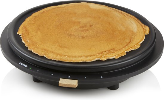 Zwarte Domo pannenkoekenmaker met één grote gebakken pannenkoek op de vlakke bakplaat.