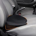 Zwart ergonomisch stoelkussen met een honingraatstructuur, geplaatst op een grijze autostoel.