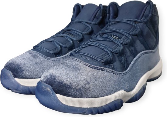 Blauwe mid-top sneakers met witte zolen en donkerblauwe veters. De schoenen hebben een fluwelen afwerking.
